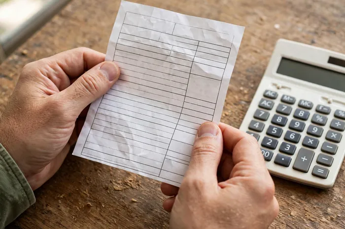 Mãos segurando contracheque de férias com a calculadora de férias ao lado